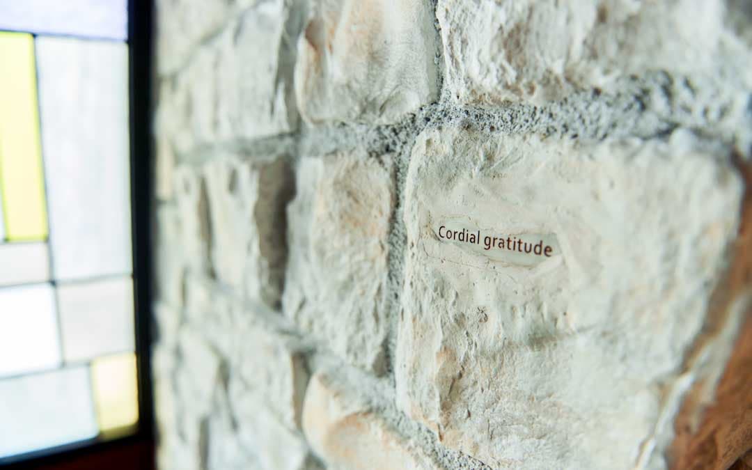 ステンドグラスの窓の隣にある石の壁に「Cordial gratitude」というメッセージが書かれています。